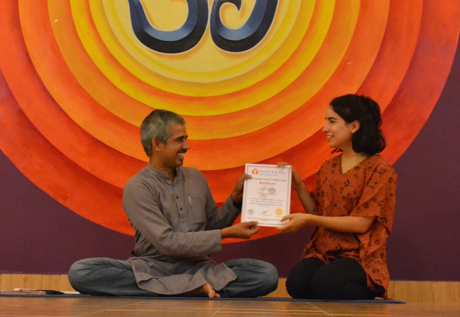 Alexia receiving her yoga teacher training certificate from Bharath Shetty